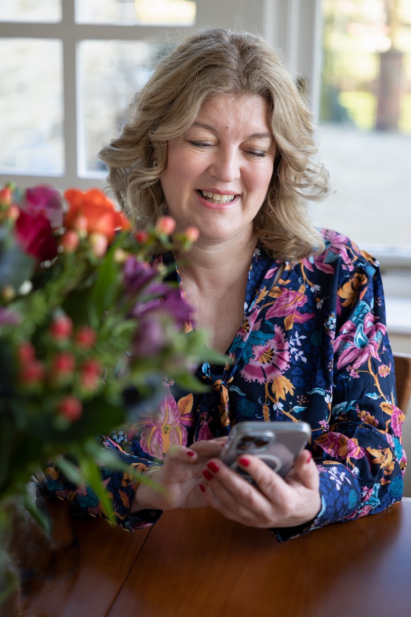 Claire Mitchell, smiling, at a table with flowers